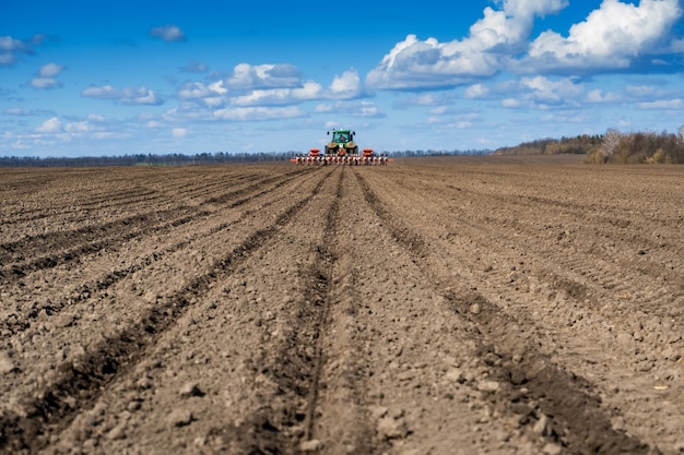 Tractor con sembradora en el campo a principios de la primavera