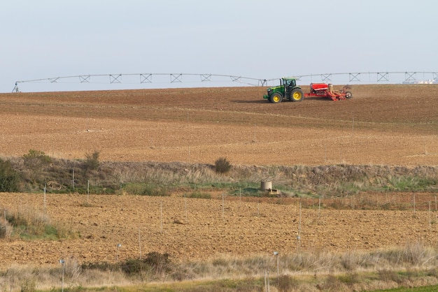 tractor con sembradora trabajando en el campo.