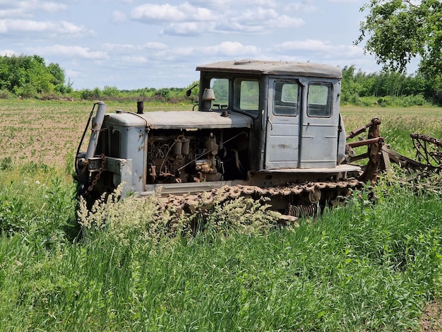 Un tractor se sienta en un campo con la palabra tractor en él.