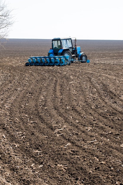 Foto tractor en el suelo negro en el momento de la siembra