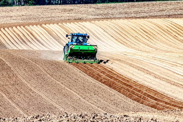 Tractor trabajando en la siembra de papas en un campo en Oensel al sur de Limburgo en los Países Bajos Holanda