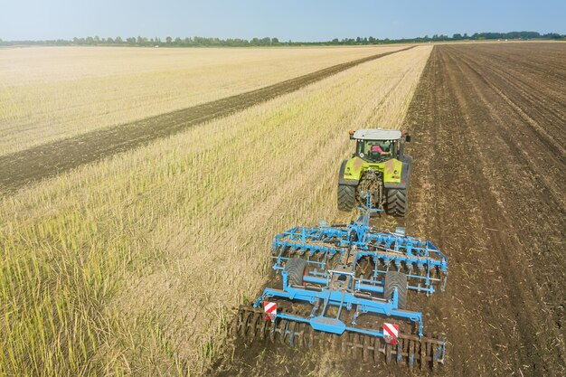 Tractor en el trabajo, cultivando un campo, Vista aérea del cultivador de semillero.