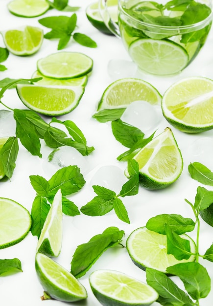 Tradición bebida de verano mojito con menta lima y hielo sobre fondo blanco.