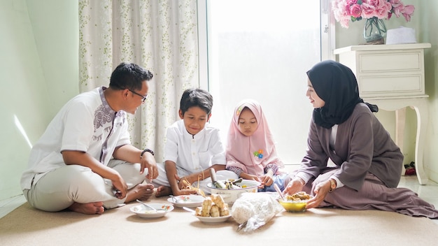La tradición familiar de Eid al-Fitr es comer ketupat opor o guarniciones.