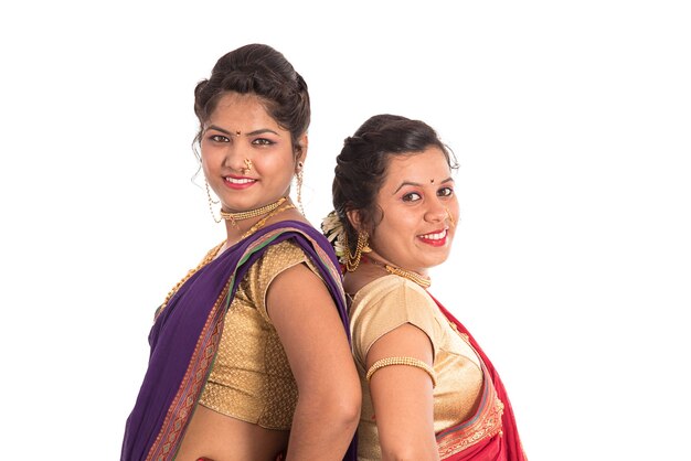 Tradicionais lindas garotas indianas em sari posando em branco