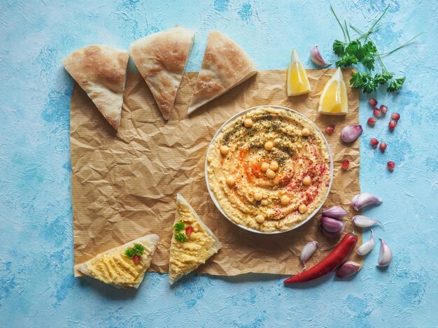 El tradicional aperitivo de Oriente Medio Hummus servido con pan de pita fresco y hierbas.