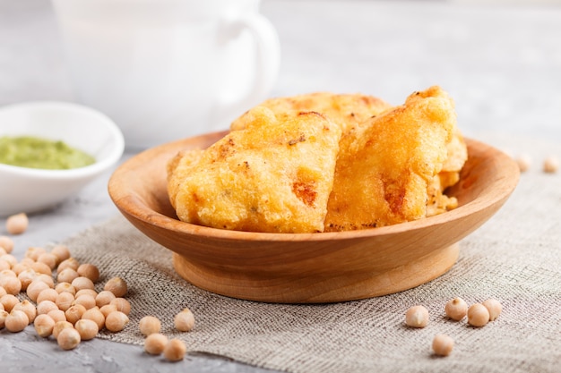 Tradicional comida indiana paneer pakora em placa de madeira com chutney de hortelã