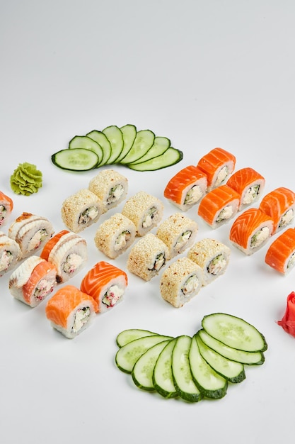 Tradicional delicioso sushi fresco set Philadelphia roll con anguila ahumada de salmón y pepino aislado sobre fondo blanco Menú de sushi Comida asiática japonesa