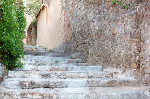 Tradicional escalera de piedra estrecha y vacía edificio de piedra verde planta en la pared destino Grecia