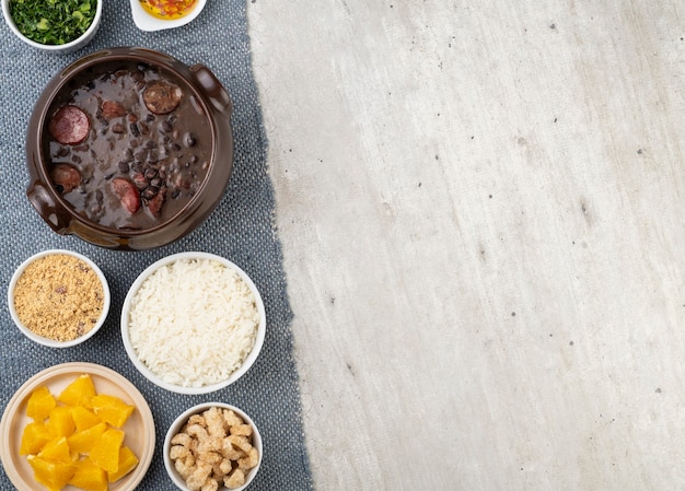 Tradicional feijoada brasileira com arroz, couve, laranja, torresmo, farinha de mandioca e copa.