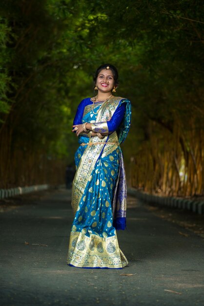 Foto tradicional india hermosa joven en sari posando al aire libre en el parque
