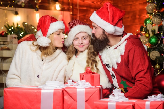 Tradiciones navideñas. Recuerdos navideños. Momentos felices. Chica en casa en Nochebuena. Los niños celebran el año nuevo con los padres. Caridad y bondad. Regalo abierto. Llena nuestra Navidad de alegría y alegría.