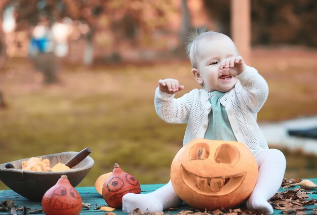 Tradiciones de otoño y preparativos para la fiesta de Halloween. Una casa en la naturaleza, una lámpara hecha de calabazas se corta en la mesa.