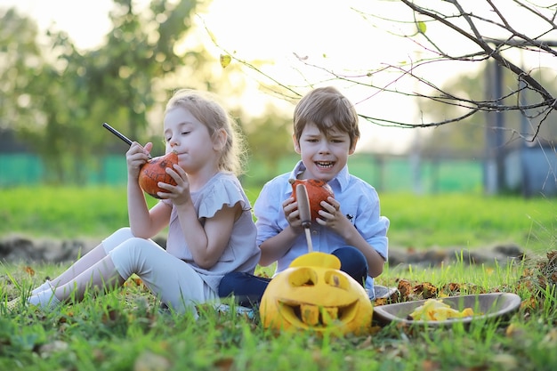 Tradiciones de otoño y preparativos para la fiesta de Halloween. Una casa en la naturaleza, una lámpara hecha de calabazas se corta en la mesa.