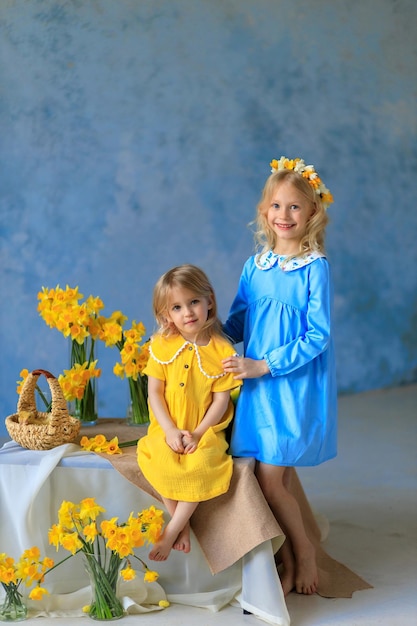 Tradiciones de pascua 2 hermosas chicas con vestidos brillantes sostienen conejos y pollos en sus manos tarjeta de pascua