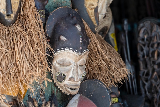 Traditionelle afrikanische Holzmasken hängen zum Verkauf auf dem Straßenmarkt auf der Insel Sansibar Tansania Ostafrika hautnah