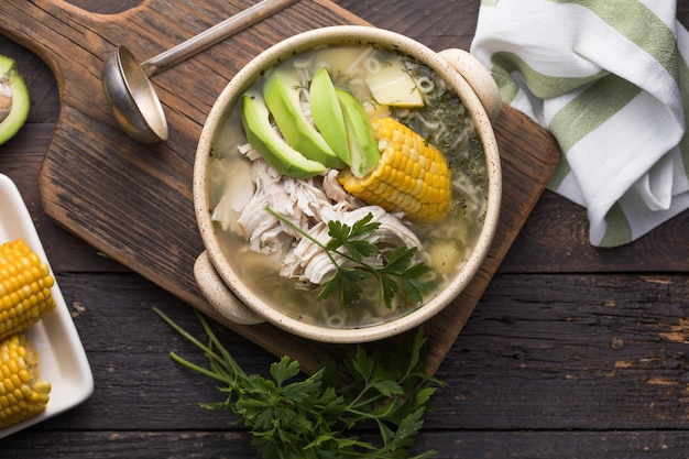 Traditionelle Ajiaco Colombiano - Kolumbianische Suppe mit Kartoffeln, Hühnchen, Avocado