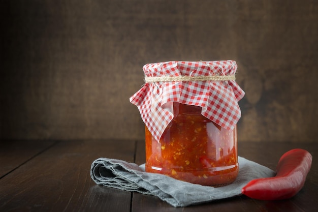 Traditionelle Ajvar Adjika aus roter Pfeffersoße Paste Harissa auf Holzbrett Tunesien georgische und arabische Küche Platz für Text