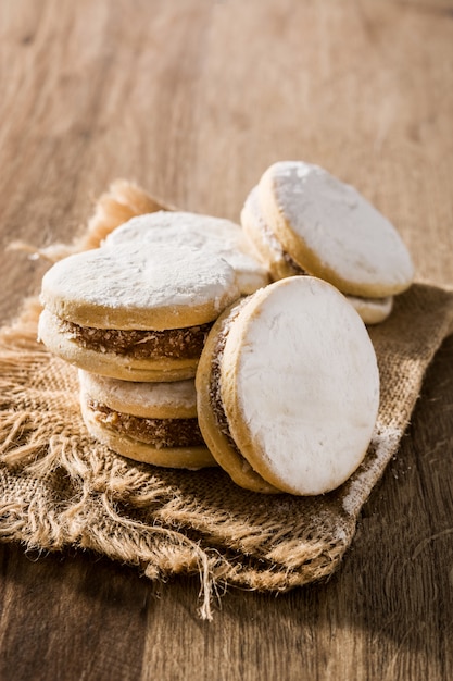 Traditionelle argentinische Alfajores mit Dulce de Leche und Zucker auf Holztisch