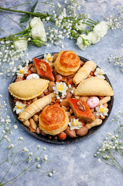 Traditionelle aserbaidschanische Feiertags-Novruz-Kekse Baklavas und Shakarburas auf schwarzer Tablettplatte auf dem grauen Beton