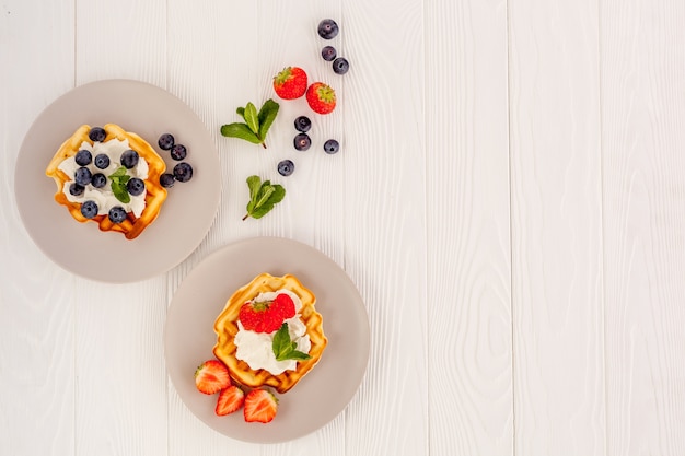 Traditionelle belgische Waffeln auf weißem Holztisch