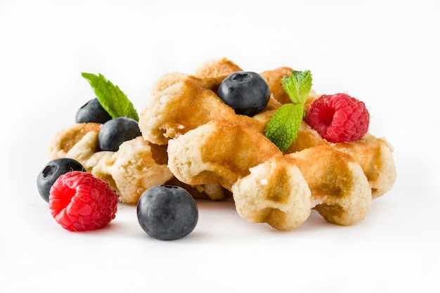 Traditionelle belgische Waffeln mit Blaubeeren und Himbeeren lokalisiert auf Weiß.