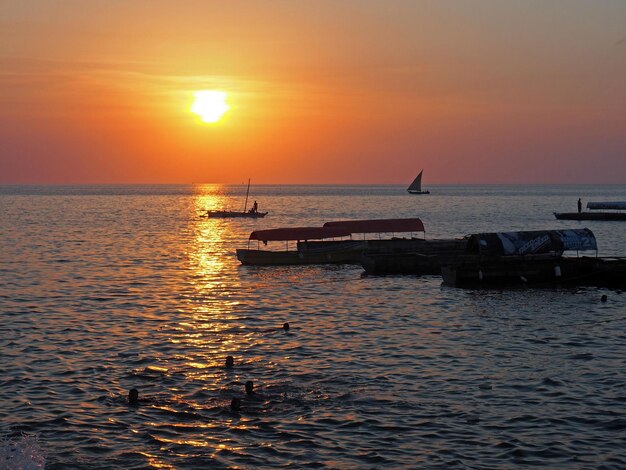 Foto traditionelle boote auf dem ruhigen wasser bei einem romantischen sonnenuntergang auf der insel sansibar