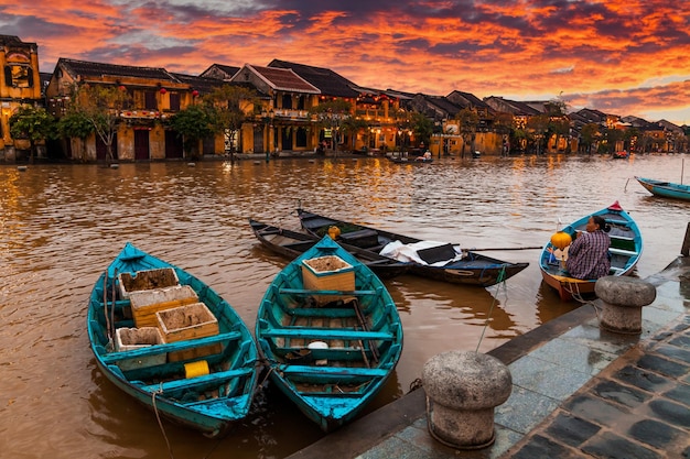 Traditionelle Boote vor antiker Architektur in Hoi An Vietnam