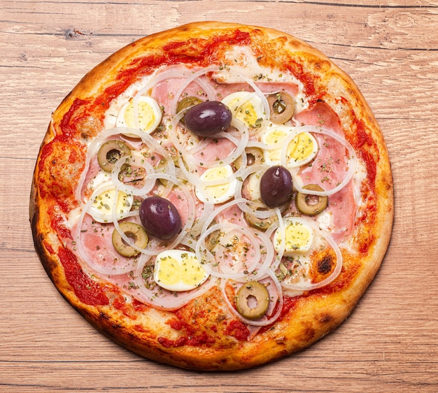 Traditionelle brasilianische Pizza mit portugiesischem Geschmack, mit Mozzarella, Eiern, Zwiebeln, Schinken und Oliven auf weißem Hintergrund.