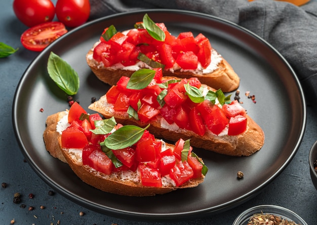 Traditionelle Bruschetta mit Tomaten, Basilikum und Frischkäse