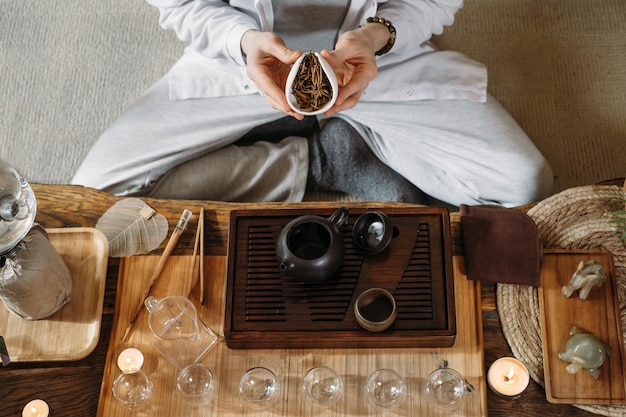 Traditionelle chinesische Teezeremonie servieren und Oolong aus einer Teekanne mit Dampf auf dunklem Hintergrund gießen