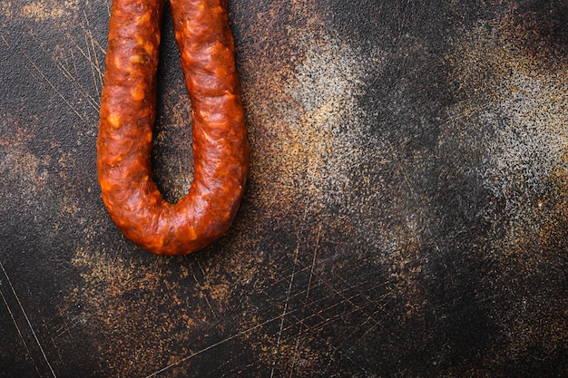 Traditionelle Chorizo-Salami-Wurst auf dunklem Hintergrund, Draufsicht mit Kopienraum.