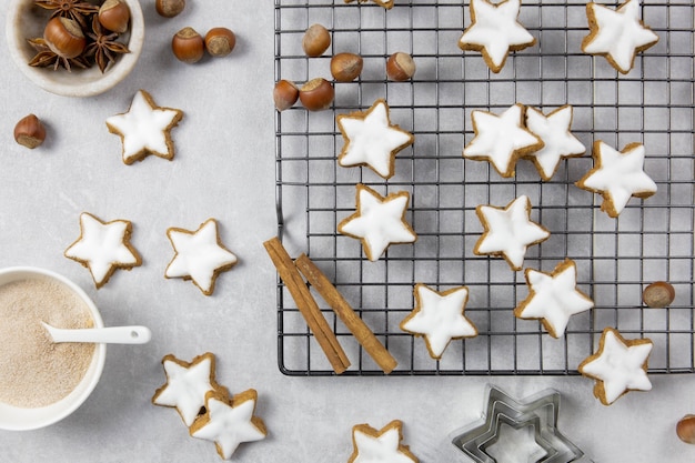 Traditionelle deutsche Weihnachtsplätzchen, Zimtsterne mit Haselnüssen auf hellem Betonhintergrund. Ansicht von oben.