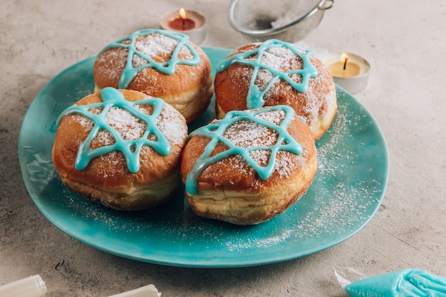 Traditionelle Donuts mit Davidstern auf einem blauen Teller