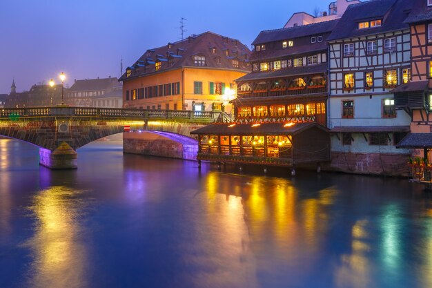 Traditionelle elsässische Fachwerkhäuser und Brücke in Petite France während der blauen Dämmerungsstunde, Straßburg, Elsass, Frankreich