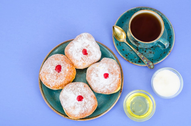 Traditionelle Food Donuts mit Puderzucker und Marmelade. Jüdischer Feiertag Chanukka.