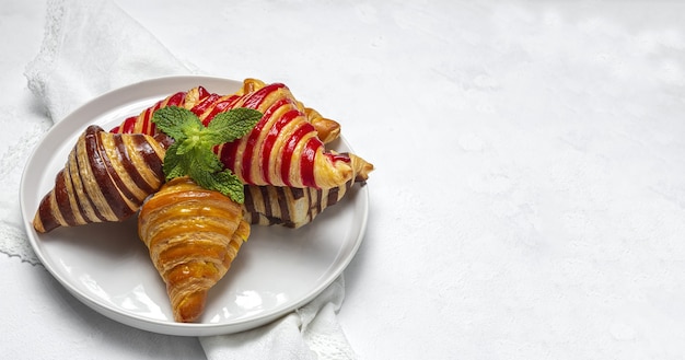 Traditionelle französische hausgemachte Croissants aus Erdbeeren, Schokolade und Vanille, frisch gebacken