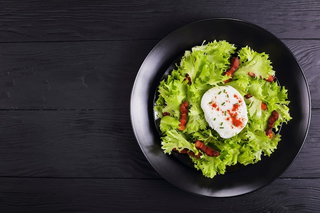 Traditionelle französische Salat-Lyonnaise mit Friseesalat, Speck und pochiertem Ei