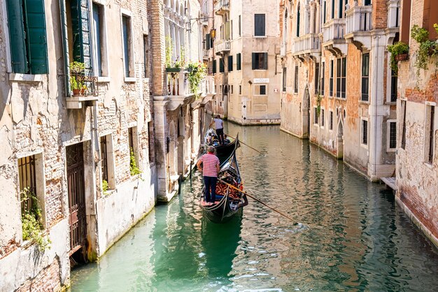 Traditionelle Gondeln auf dem schmalen Kanal in Venedig, Italien. Erkunden Sie das schöne Venedig an einem sonnigen Tag auf dem Wasser.
