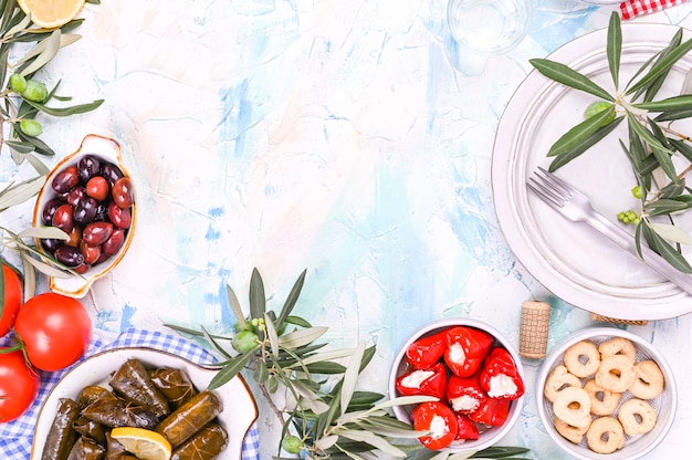 Traditionelle griechische Küche. Eingewickelter Reis in Weinblättern. Dolma mit Zitrone, Gewürzen, verschiedenen eingelegten Oliven und Peperoni. Frische Zweige und hausgemachtes Essen