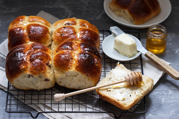 Traditionelle heiße Brötchen mit Honig und Butter auf einer Betonoberfläche