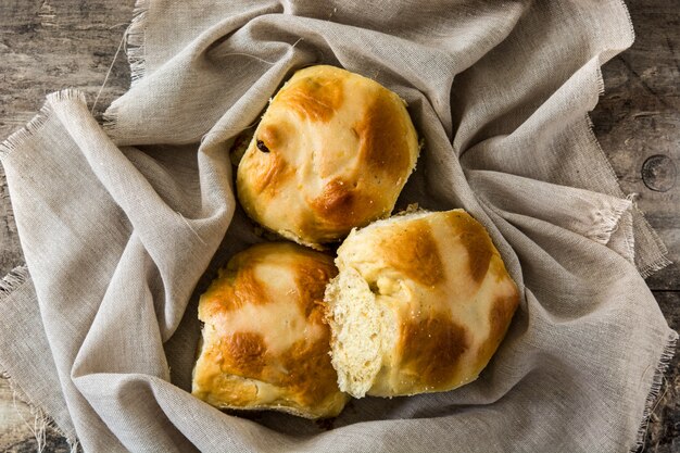 Traditionelle heiße Querbrötchen Ostern auf Holztisch