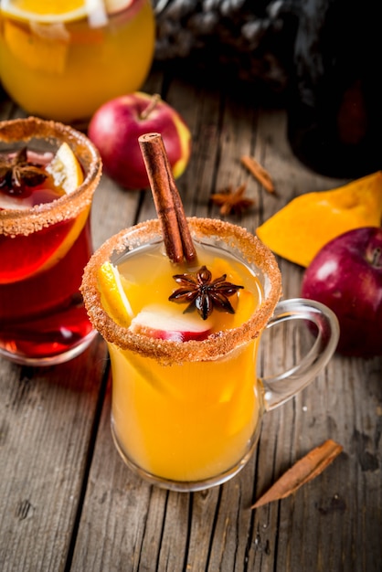 Traditionelle Herbst- und Wintergetränke und Cocktails. Heiße würzige Sangria des weißen und roten Herbstes mit Anis, Zimt, Apfel, Orange, Wein. In Glasbechern alter rustikaler Holztisch. Tiefenschärfe textfreiraum