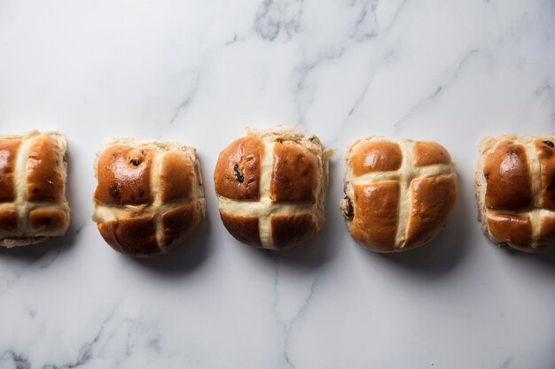 Traditionelle Hot Cross Buns mit Rosinen auf einer Marmoroberfläche