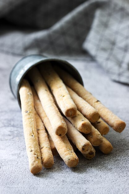 Traditionelle italienische Grissini mit Leinsamen auf einer grauen Oberfläche