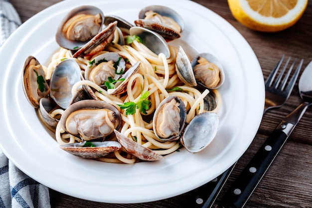 Traditionelle italienische Pasta mit Meeresfrüchten mit Muscheln Spaghetti alle Vongole auf Holzhintergrund