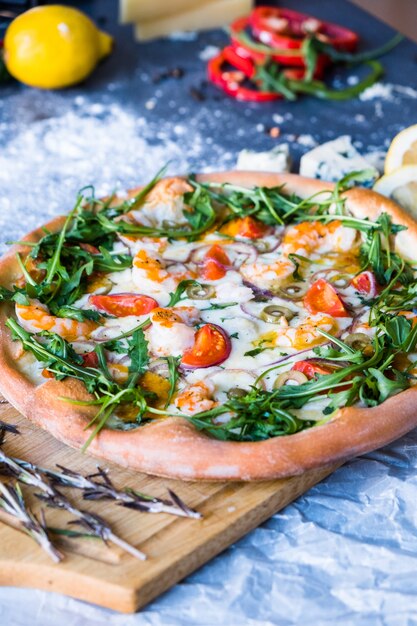 Traditionelle italienische Pizza mit Garnelen, Mozzarella und Arugula auf dunkelblauer Steintabelle