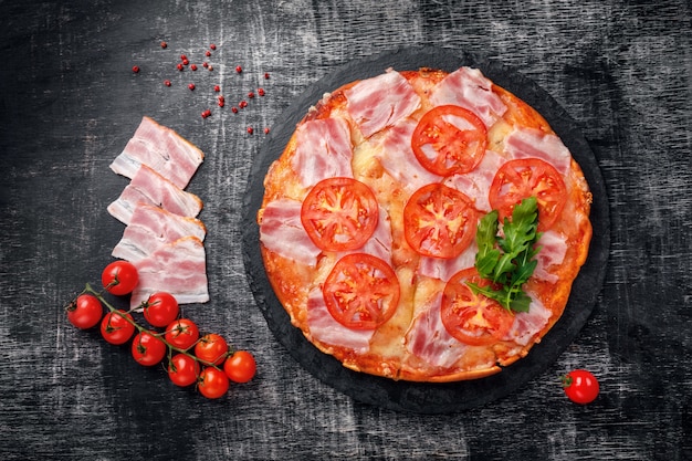 Traditionelle italienische Pizza mit Mozzarellakäse, Schinken, Tomaten, Pfeffer, Pepperoni-Gewürzen und frischem Rucola