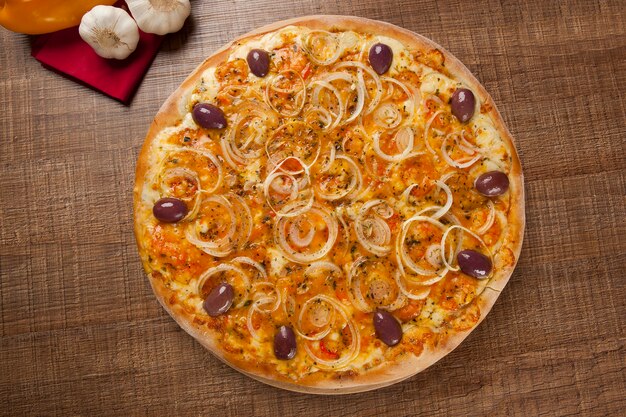 Traditionelle italienische Pizza mit Zutaten auf Holz.