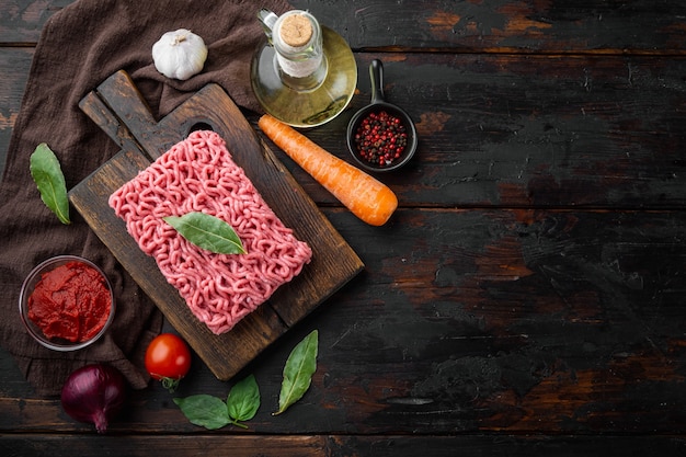 Traditionelle italienische Tomatensauce Bolognese mit Zutaten Hackfleisch Tomate und Kräutern auf Holzschneidebrett auf alten dunklen Holztisch Tisch gesetzt